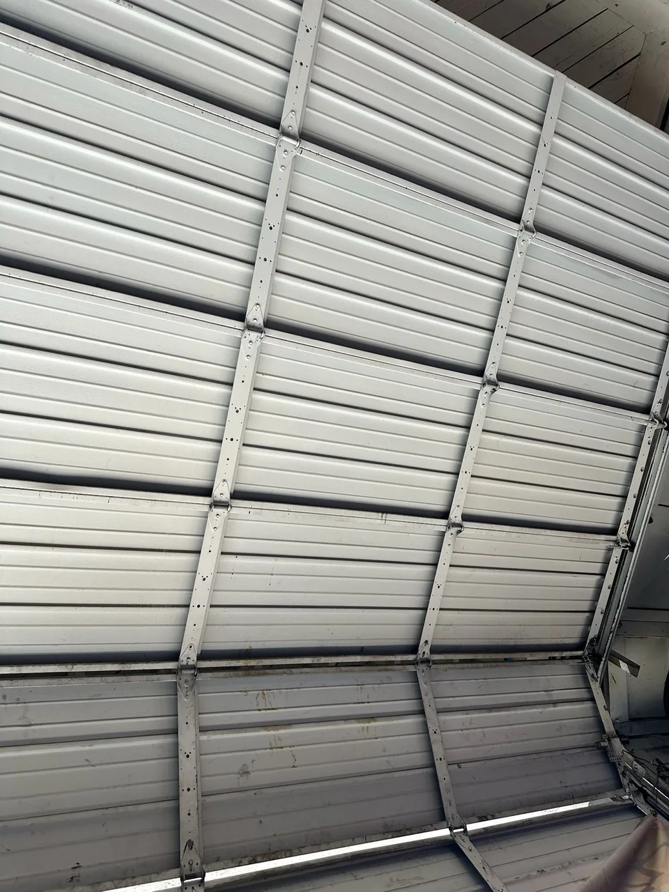 Interior view of sectional door panels with visible deformation near a joint