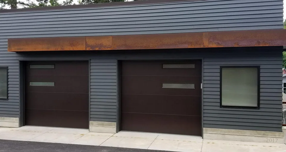 Two sectional garage doors in a clad building exterior