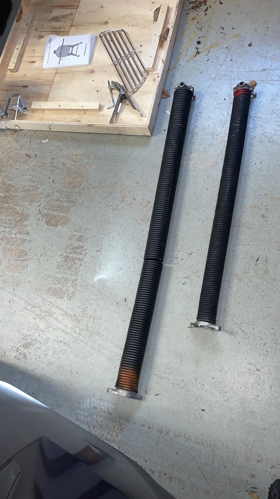 Two torsion spring assemblies showing the spring coils and end fittings